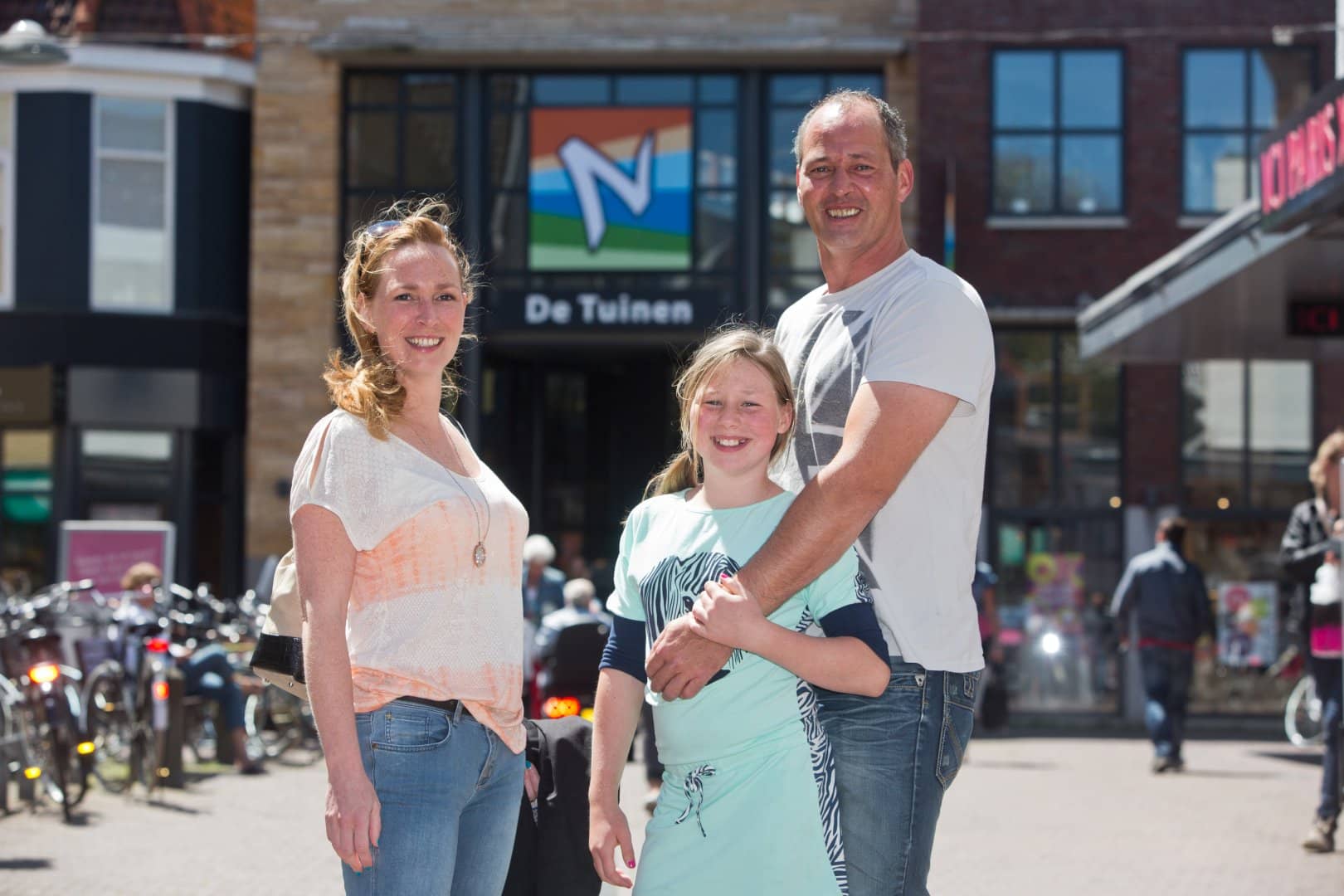 gezin met jonge dochter poseren voor de ingang van Winkeldentrum de Tuinen in Naaldwijk in het Westland