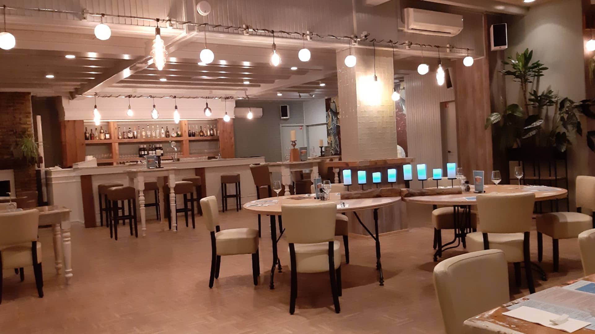 restaurantgedeelte met witte tafels en stoelen bij Eindeloos uit eten in het Westland