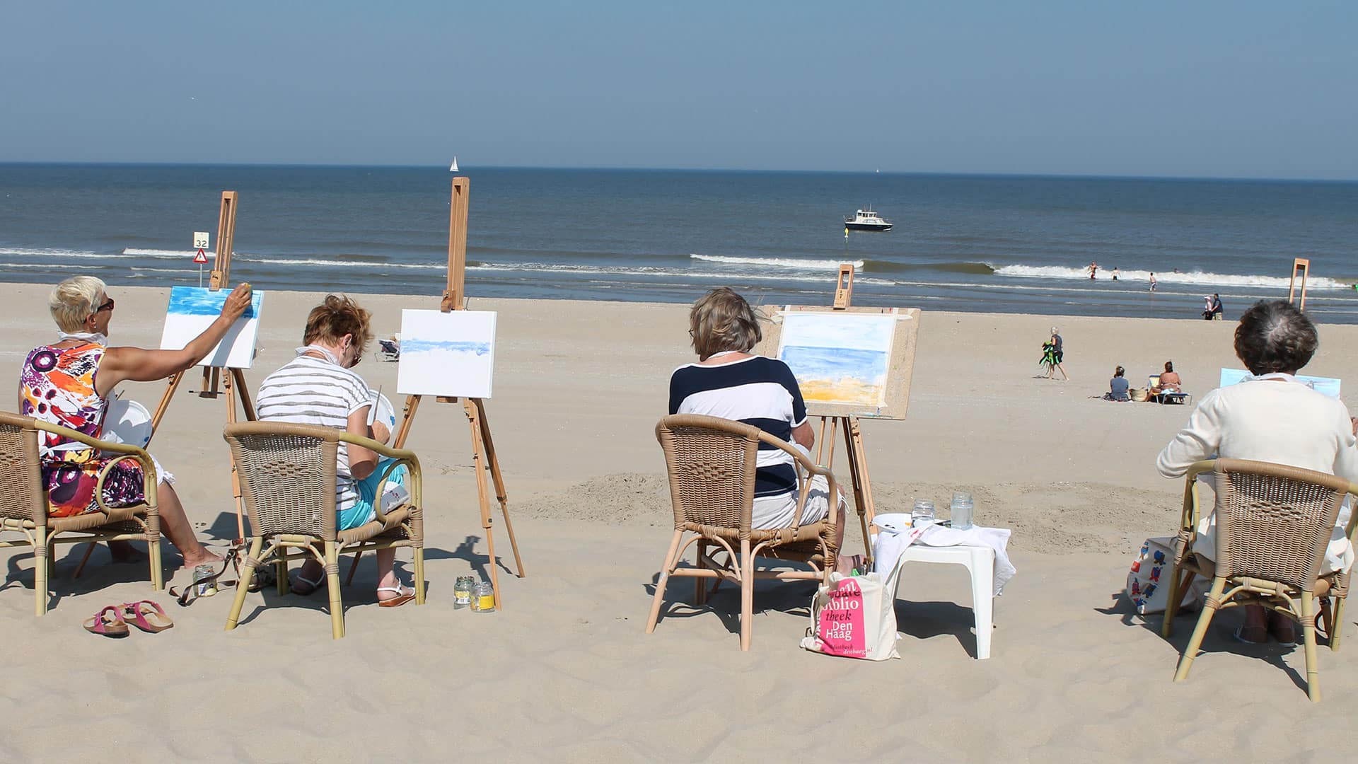 groep van 4 vrouwen zit op het strand te schilderen tijdens een schilderworkshop van Cast-Art op het strand in het Westland