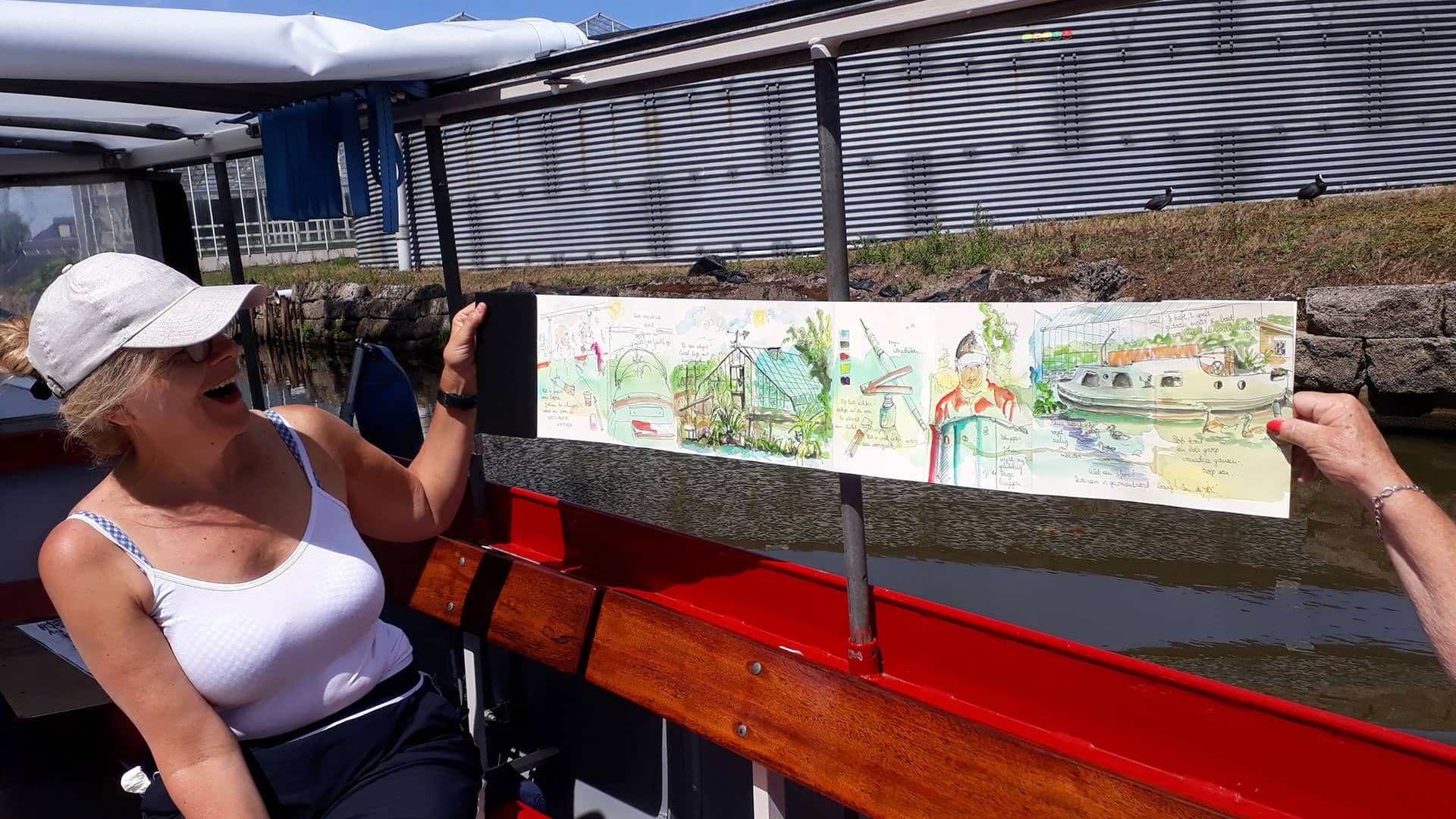 mevrouw houdt een tekening omhoog die ze heeft gemaakt tijdens een schilderworkshop van Cast-Art aan boord van rondvaartschip De Gantel in het Westland