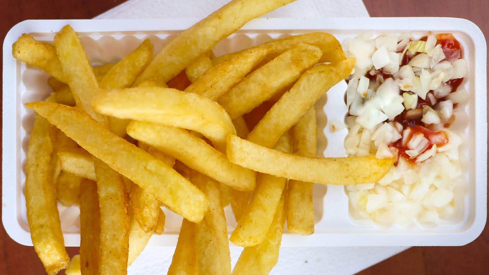 wit plastc bakje met een frietje met ketchup en uitjes tijdens een rondvaart door het Westland