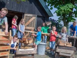 groepje jongens en meisjes zijn bezig met een timmerworkshop met houten druivenkistjes bij het Westlands Museum in het Westland
