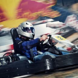 man rijdt op hoge snelheid in een kart van Van der Ende Racing Inn op de grootste indoor kartbaan van Europa in het Westland