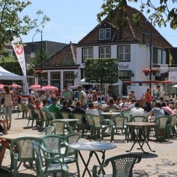 terrassen met tafels en stoelen en mensen die genieten van de zon op het Marktplein in 's Gravenzande in het Westland