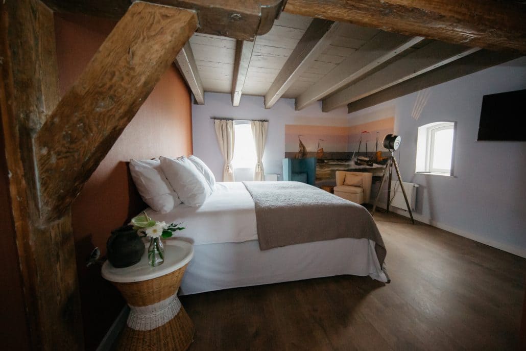kamer van Boutique Hotel De Gravin in het Westland met bed, houten balken en muurschildering
