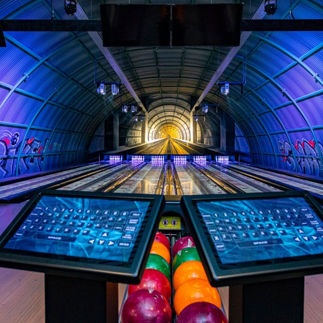 glow in the dark bowlingbaan in een metalen loods met fel gekleurde bowlingballen in entertainment center The City in het Westland