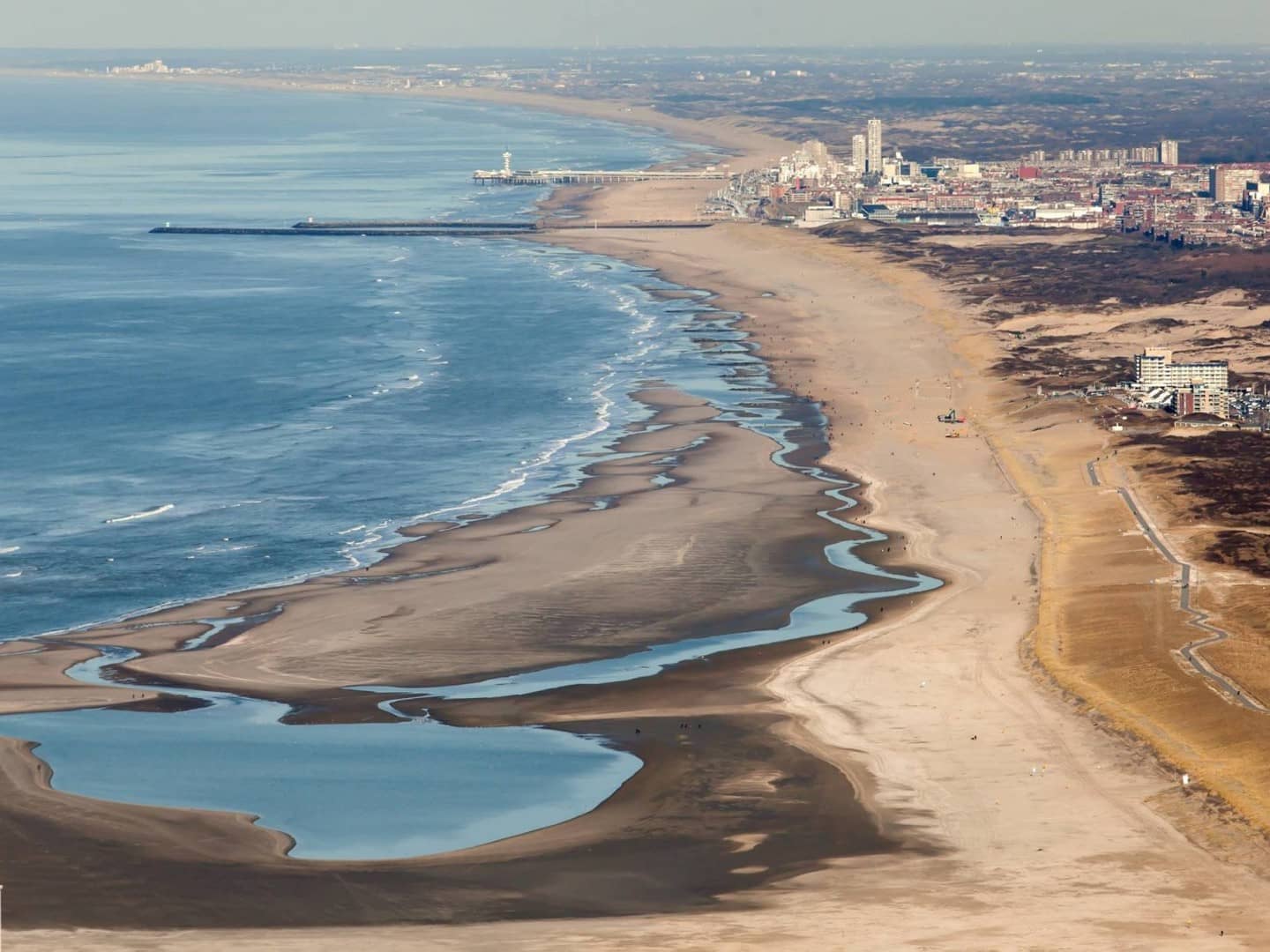 luchtfoto van de Zandmotor bij de kust van Monster met een leeg strand een binnenmeer