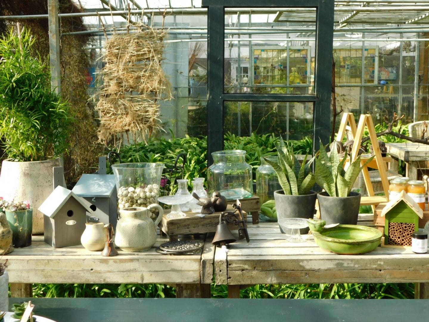 tafel met planten en attributen voor bloemschikken in een kas van Het Natuuuratelier in het Westland