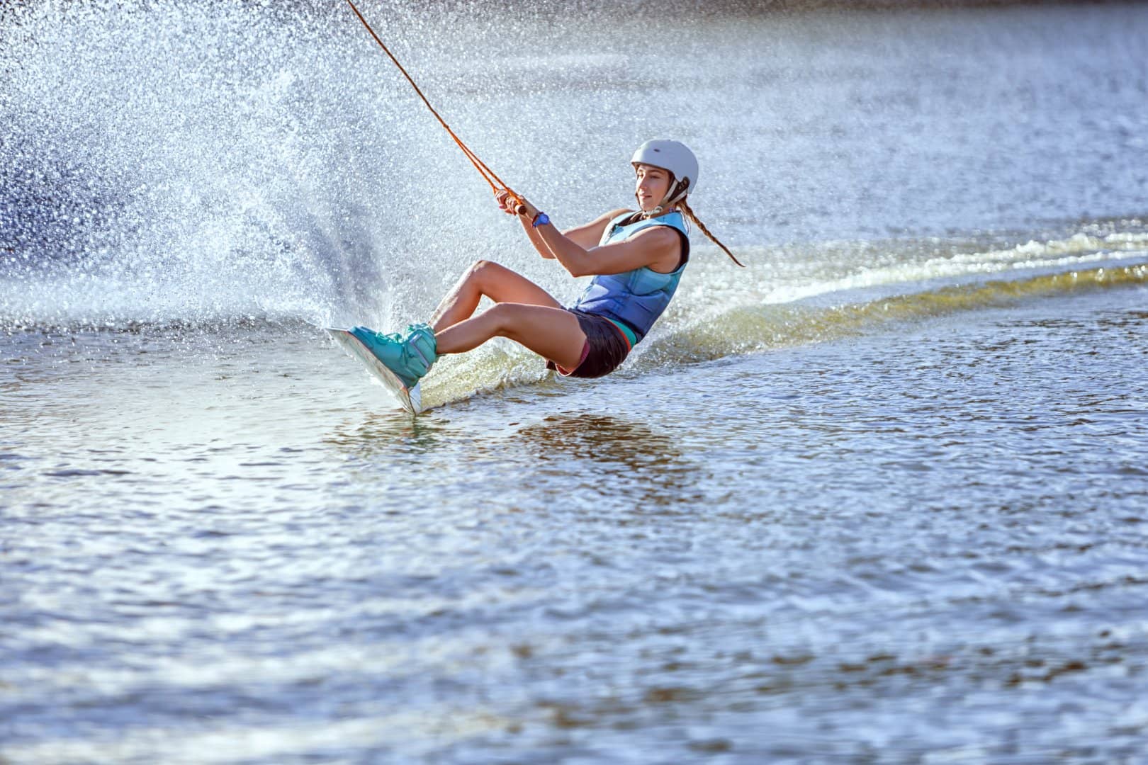 jonge vrouw op een wakeboard op het water voortgesleept door de kabelbaan van Wollebrand Cablepark in het Westland