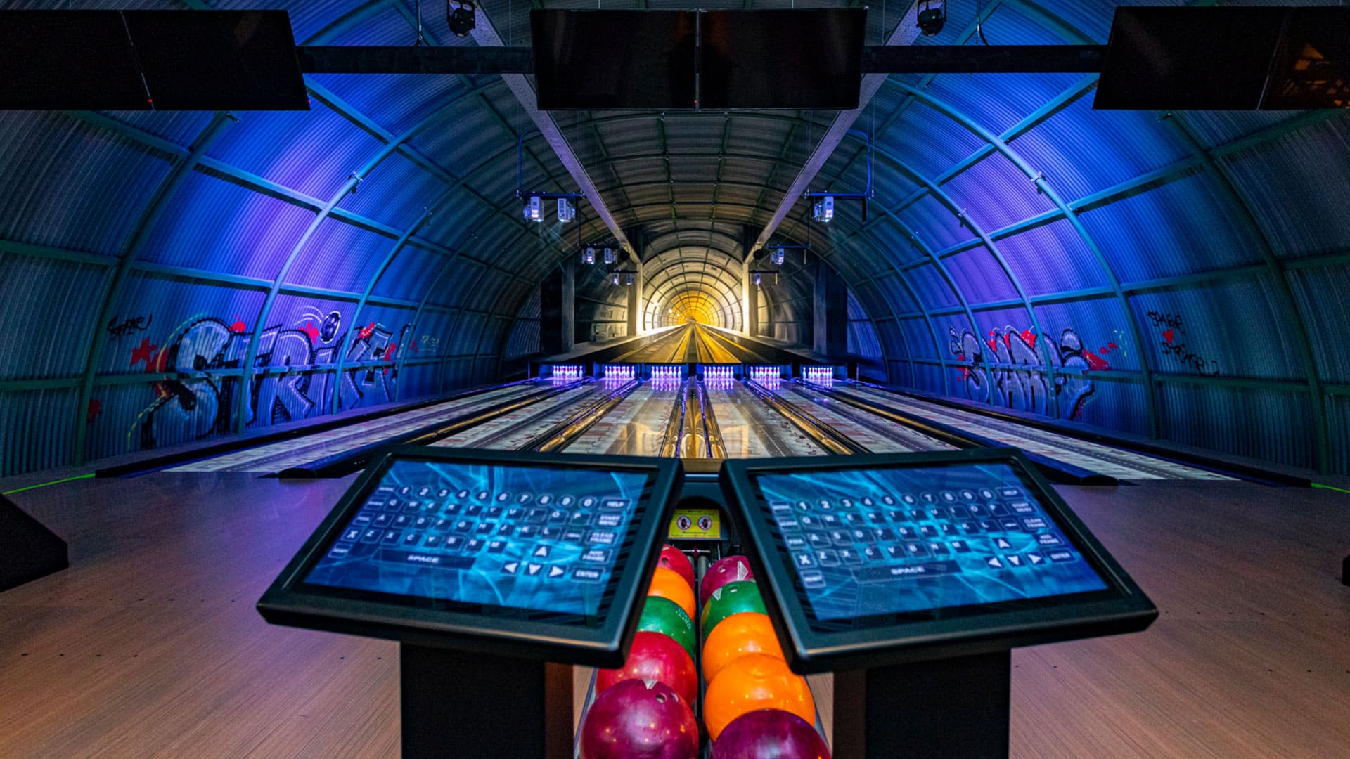 glow in the dark bowlingbaan in een metalen loods met fel gekleurde bowlingballen in entertainment center The City in het Westland