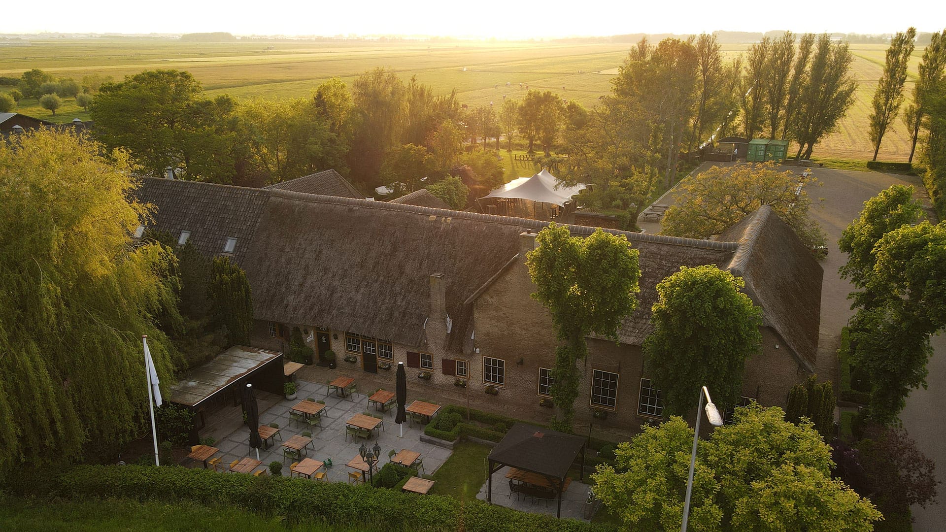 luchtfoto van de boerderij van Brasserie Oostgaag met het terras aan de voorzijde en de achterzijde van het pand in Midden-Delfland