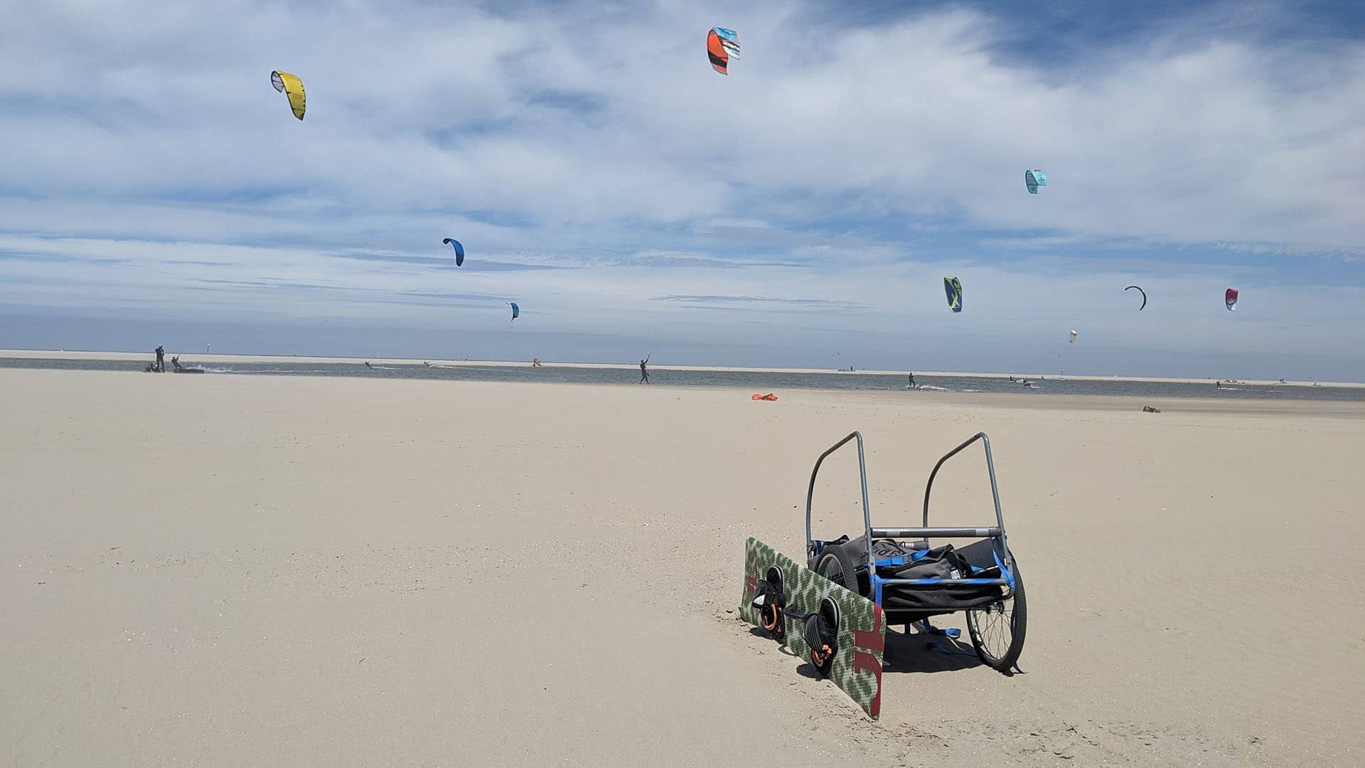 kar met kitesurfspullen op de Zandmotor in het Westland op een zonnige zomerse dag met in de achtergrond kites die aan het varen zijn