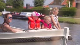 familie met 3 kleine kinderen vaart in een luxe sloep over de rivier de Zweth in het Westland tijdens een gezinsvakantie in de Zwethzone in het Westland