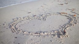 hart getekend op strand zand zee