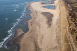 luchtfoto van het brede strand van de Zandmotor in het Westland en strandtent The Coast in het Westland