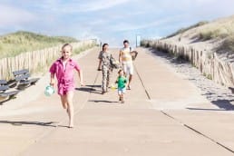 Gezin strand strandopgang westland meisje in roze gezin vakantie dagje strand Monster