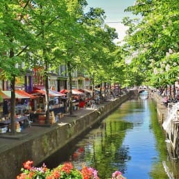 Gracht van de Hippolytusbuurt in Delft in de zomerzon met links en rechts kraampjes van de markt
