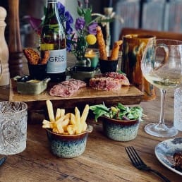 tafel met bordjes met spareribs en kleine gerechtjes als shared dining bij Bistro De Herberg in het Westland