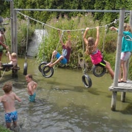 De zweth speelparadijs voor kinderen in kwintsheul westland met survivalbaan minigolf e-sloepen kano's fietsverhuur kinderen die spelen op een survivalbaan met touwen en autobanden boven het water